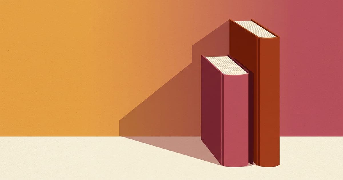 Two hardcover books of different heights standing upright on a desk