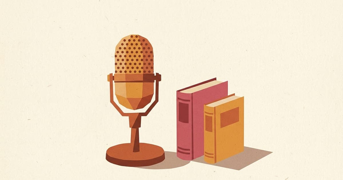 A vintage table microphone beside two closed hardcover books