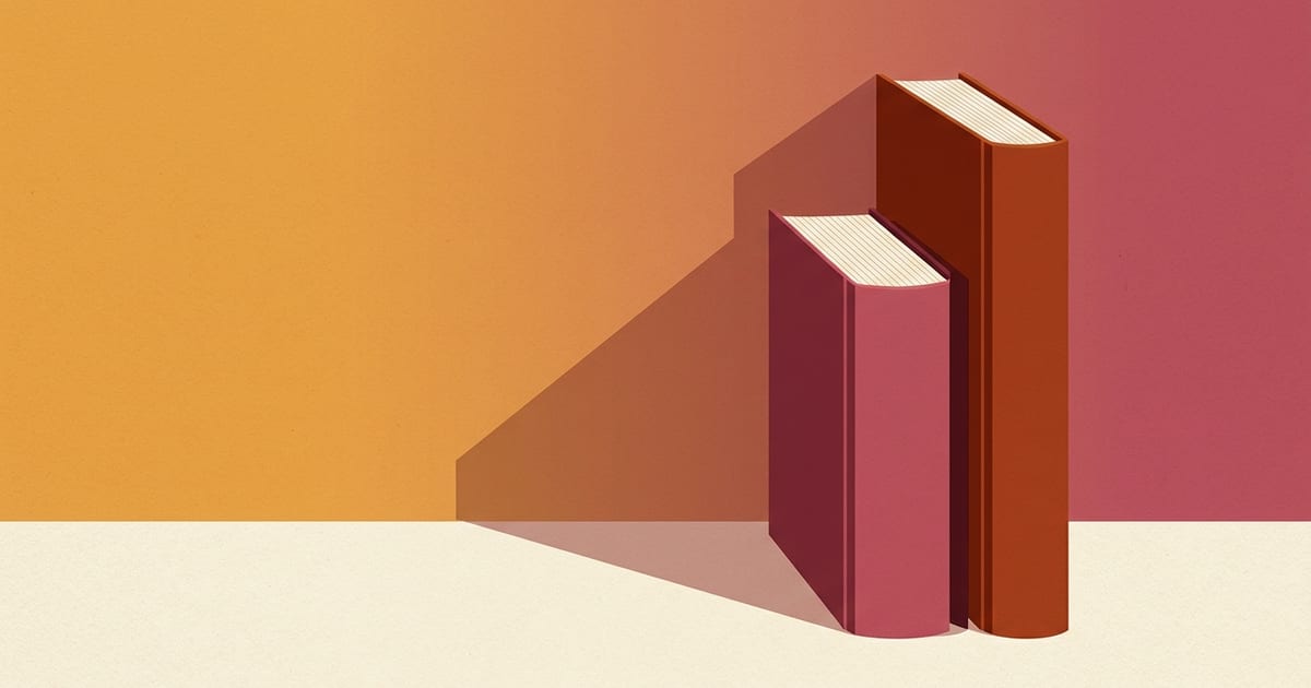 Two hardcover books of different heights standing upright on a desk