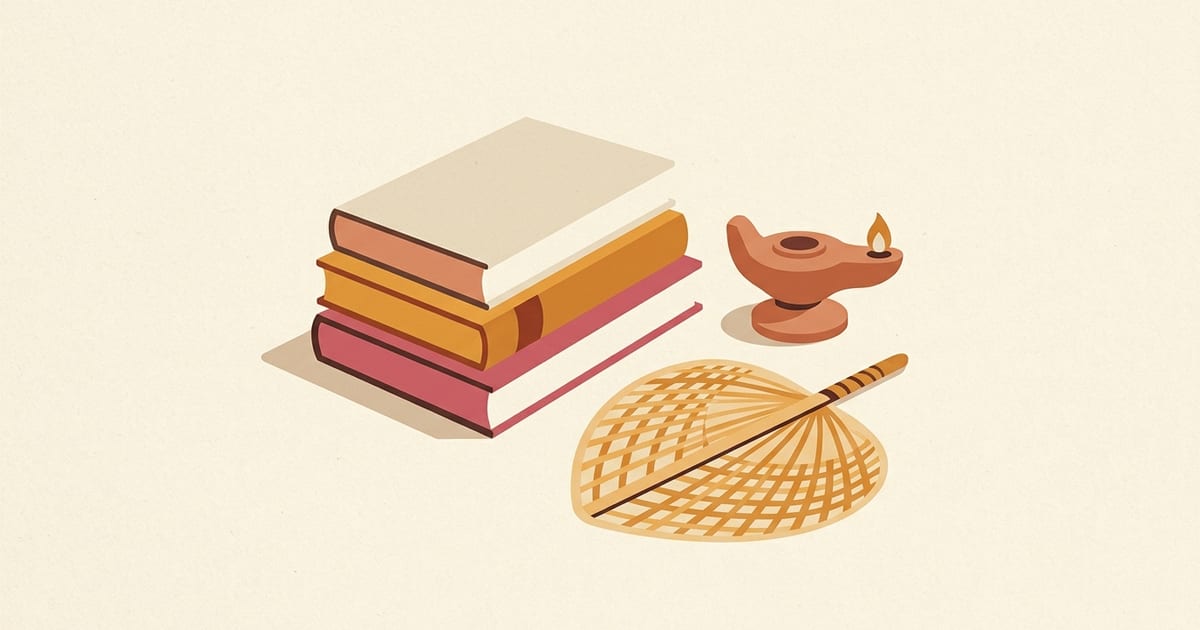 A stack of books beside a carved stone oil lamp and a palm-leaf fan